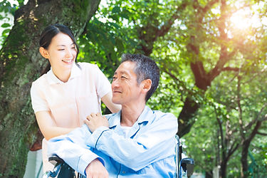 車椅子に乗った高齢者と介助者