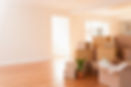 Boxes stacked on the wooden floor of a new house