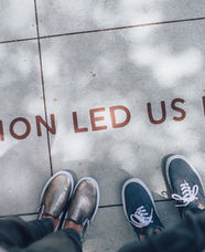 Two pairs of feet standing in front of the words "passion led us here". 
