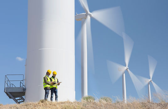 Workers talking by wind turbines