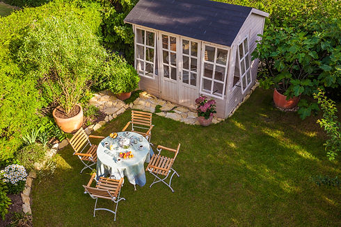 Aerial view of a grey garden summer house with outdoor table and chairs