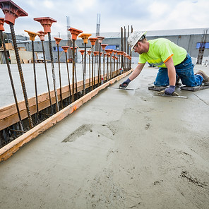 Worker finishing concrete at construction site