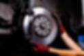 A professional repairing a car brake