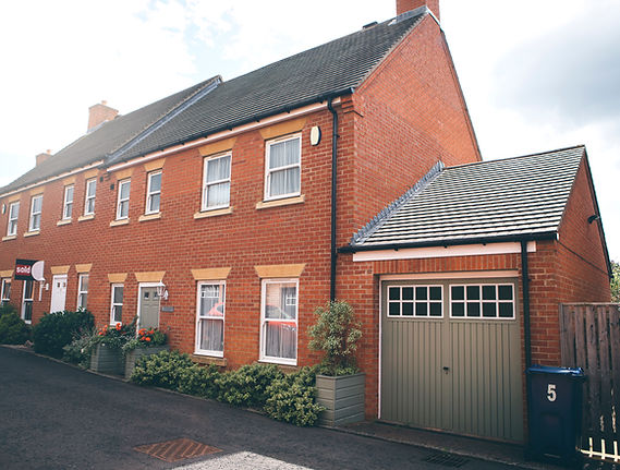 Landscape image of a house that has a 'Sold' sign on the front