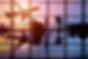 Silhouetted passengers in a modern airport terminal at sunset