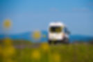 Image of a minibus with a natural background of hills and sky