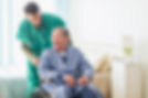 Male nurse wheeling patient in the home