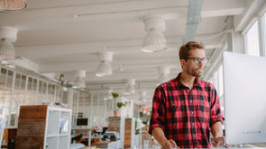Business leader reviewing data on a computer screen in a modern office.