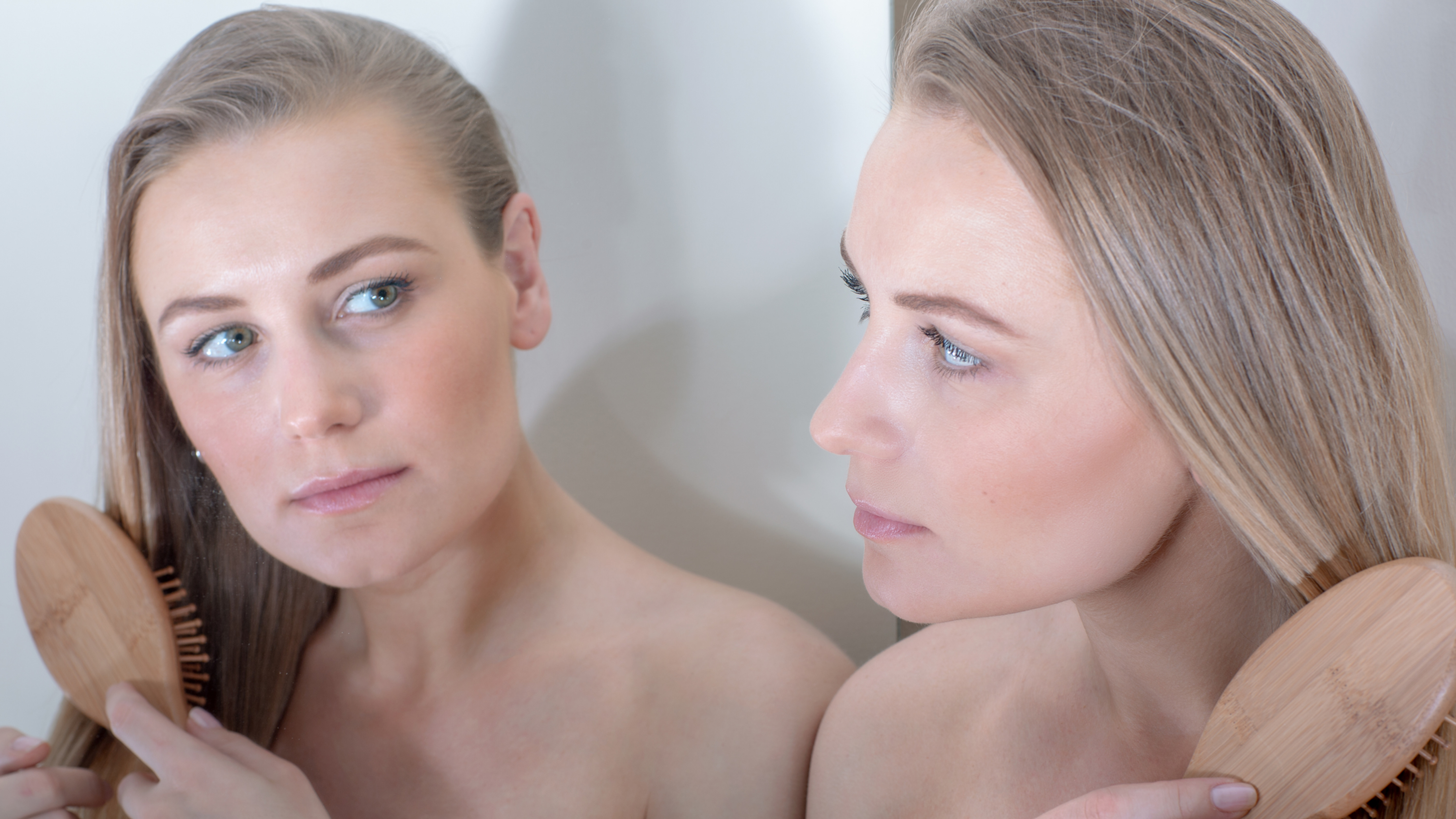 woman checking lip, chin and sideburns for signs of facial hair