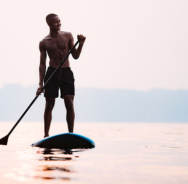 Man Paddleboarding on Water