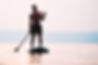 Man Paddleboarding on Water