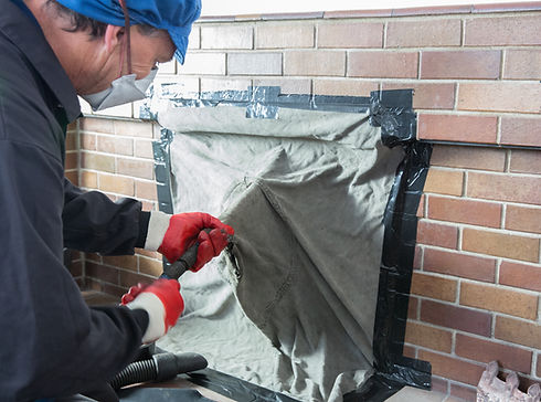 Chimney sweep wearing a mask for protection whilst cleaning chimney