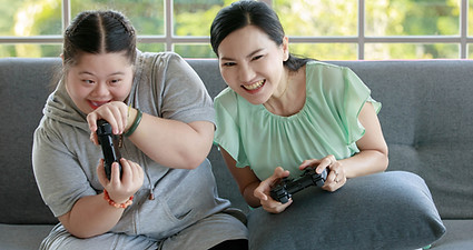 dochter met het syndroom van Down speelt computerspel met haar moeder