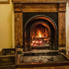 Old fireplace with a wooden (oak) surround, wood box, ash on the floor