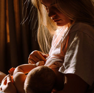 Exhaausted postpartum mother breastfeeding her baby. Low iron and postpartum bleeding support. 