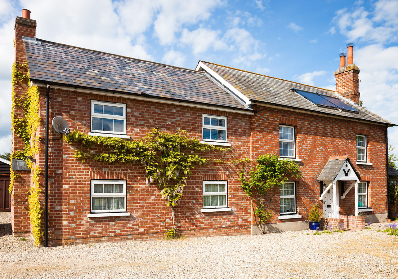 Brick built cottage with slate roof and hot water solar panels on the roof