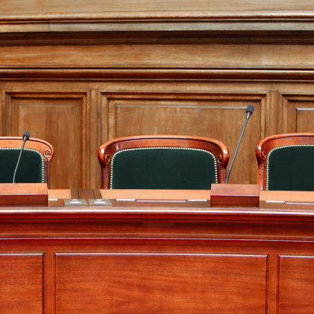 Chaises d'audience disposées dans un tribunal, symbolisant un cadre juridique formel.