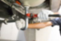 A person wearing white gloves uses a red adjustable wrench
