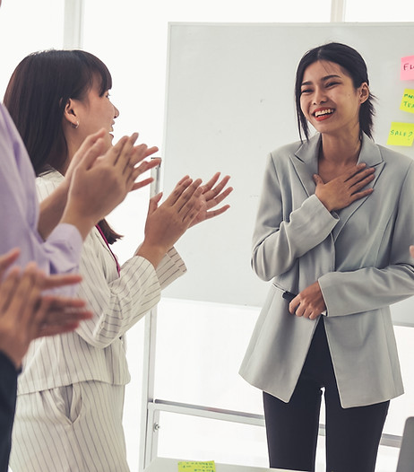 A woman applaused by people in a room