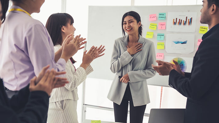 A woman applaused by people in a room