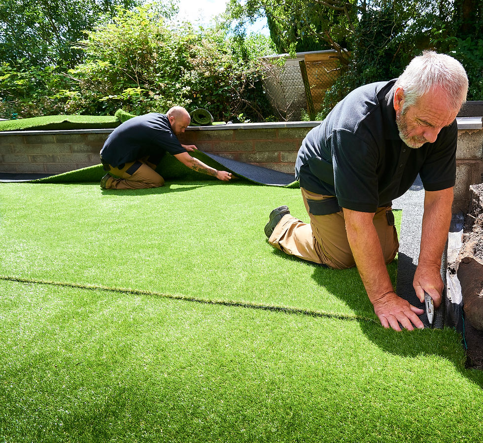 Workers installing artificial grass in a garden
