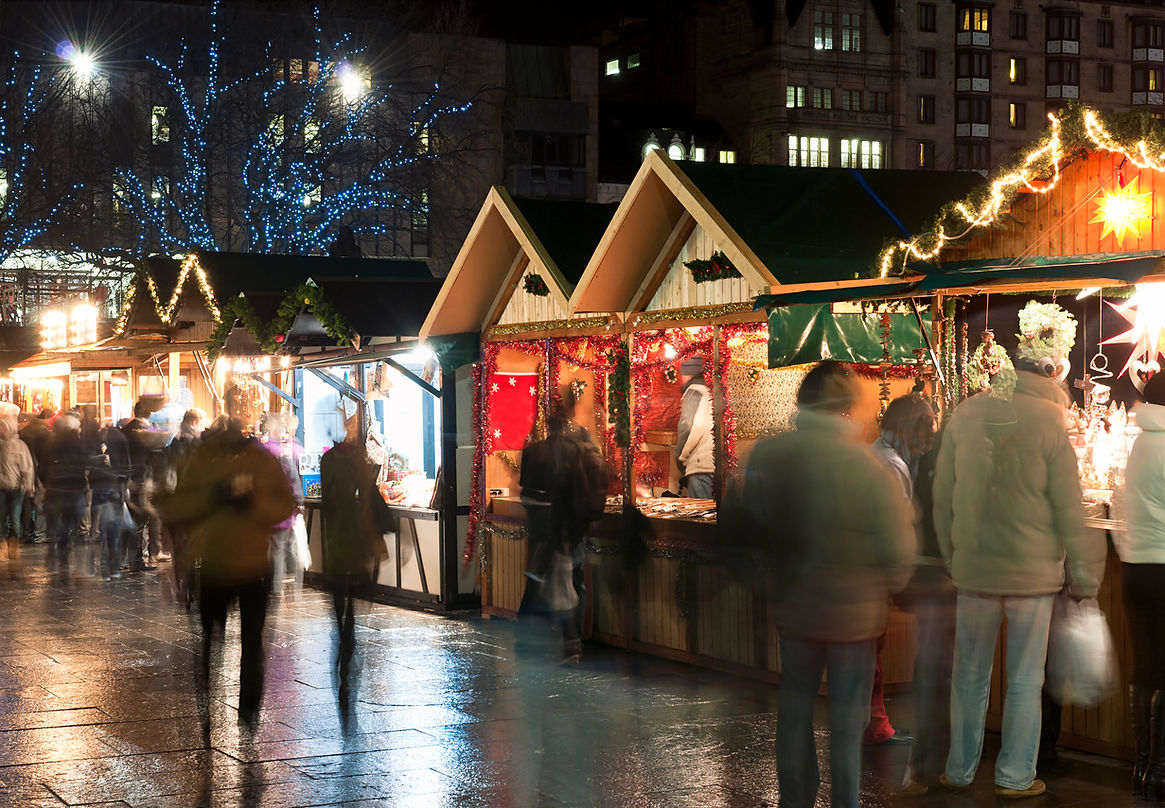 Long exposure blurring customers at a Christmas Market in Central London, showcasing street food and mobile caterers
