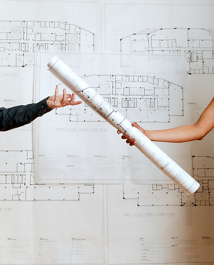 Woman handing blueprints to man, close-up of arms