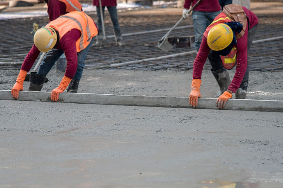 Construction worker troweling wet concrete on a top of concrete floor slab new constructio