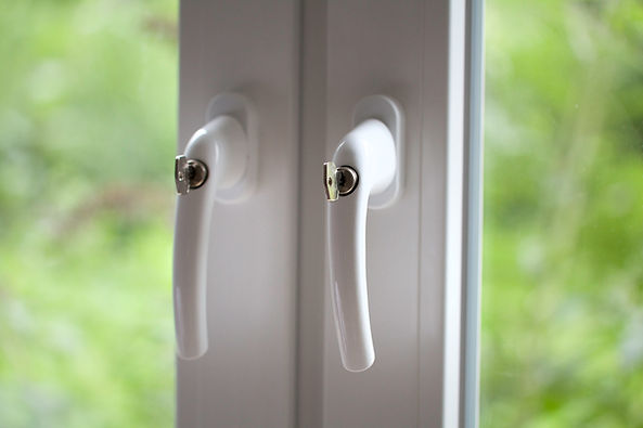 Close-up of two white window handles on a double-glazed window