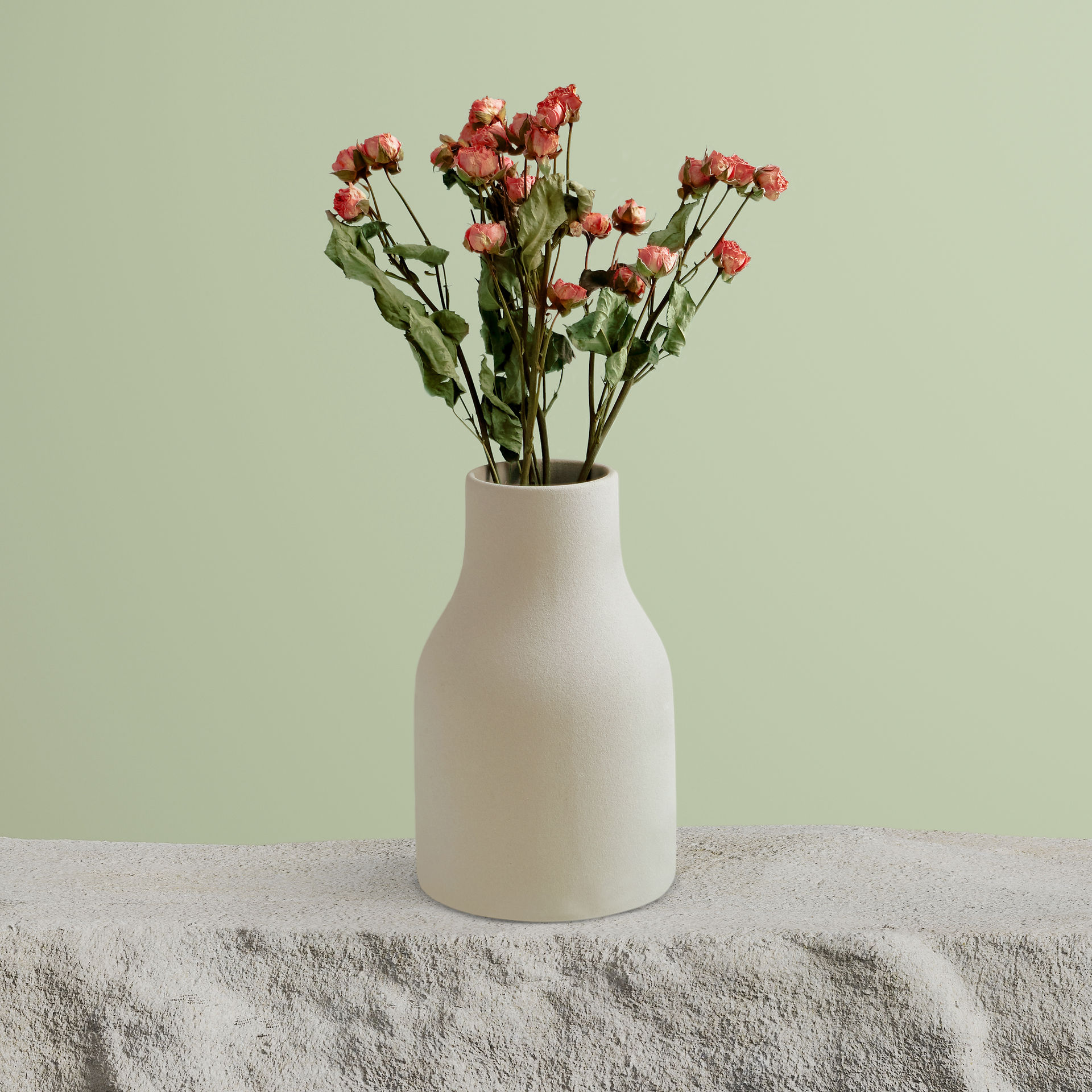 A white vase, placed on a table, containing pink flowers, adds a touch of colour and a friendly atmosphere to the interior.