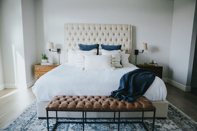 Cozy bedroom with a large bed, pillows, and a brown bench.