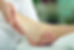 A close-up of a person's foot being gently held by another person's hands