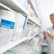 Pharmacist reading medicine bottle in pharmacy