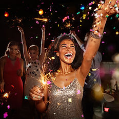 Ladies holding their hands up, holding sparklers and smiling while celebrating New Year