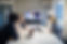 Business team in a conference room having a video call with a female colleague on a large screen
