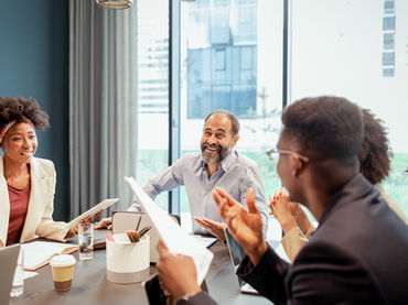 Four people at an office table having a conversation