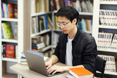 A guy using a computer in a library