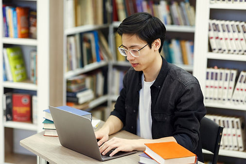 A guy using a computer in a library