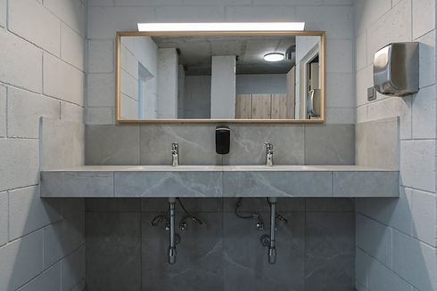 Modern restroom with gray marble sinks, and a large rectangular mirror