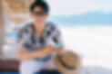 A guy playing with mobile phone at the beach