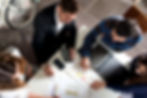 Structural surveyors and business owners looking over financial paperwork to reach a decision on a project's feasibility