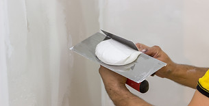 Tradesperson working on a ceiling inside a house
