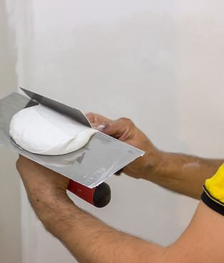 Mixing skimming plaster on trowel for the patching