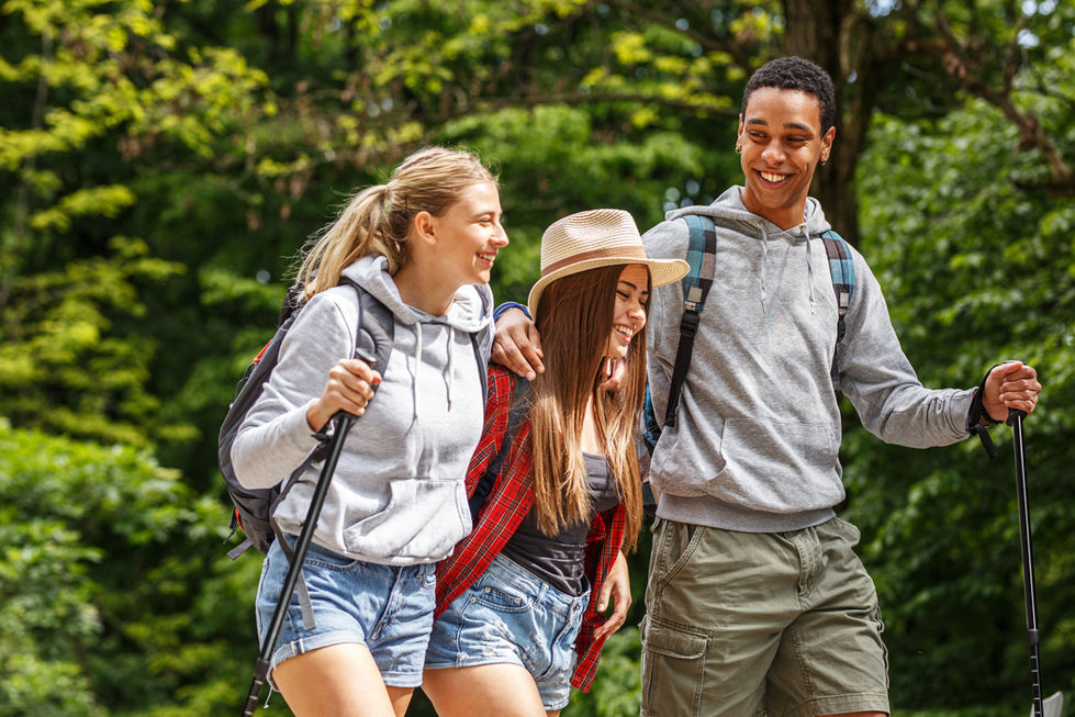 Three friends hiking in a forest, smiling and enjoying their adventure.