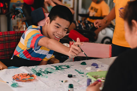 teenage boy with disability painting in art class