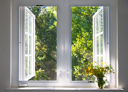 Bright open double glazed casement window with white frame overlooking green garden