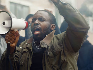 Protester with megaphone leading a strike, representing the challenges of strike management and strategies businesses need to protect operations in South Africa.