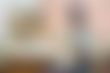 A person sitting at their computer with headphones on. 