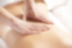A woman giving a back massage to a female patient