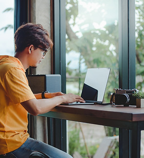 Person Working On Laptop At Window Seat